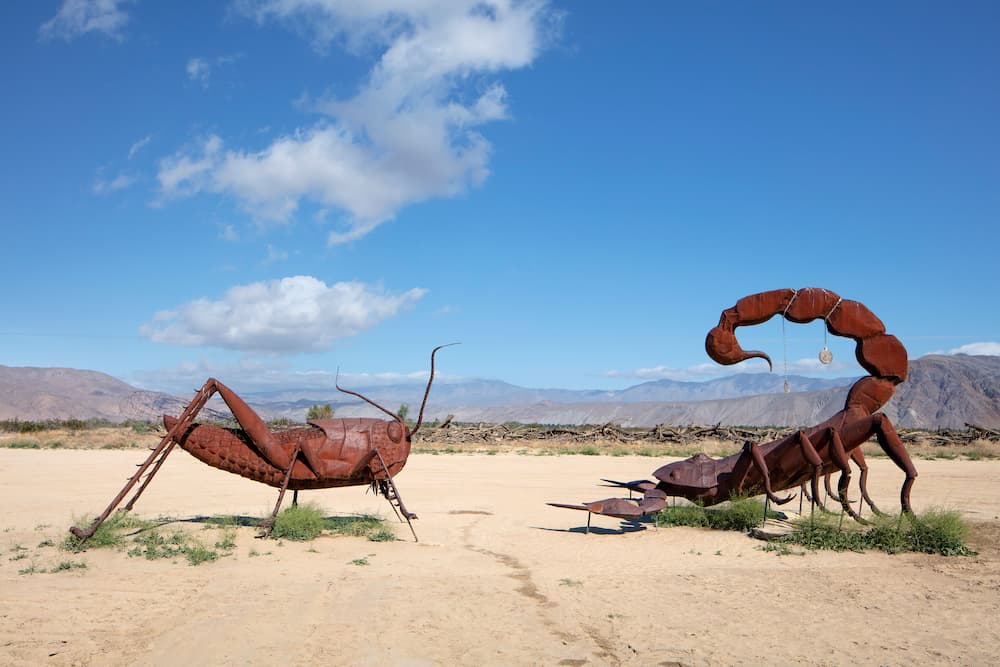Scorpion and grasshopper sculptures facing off